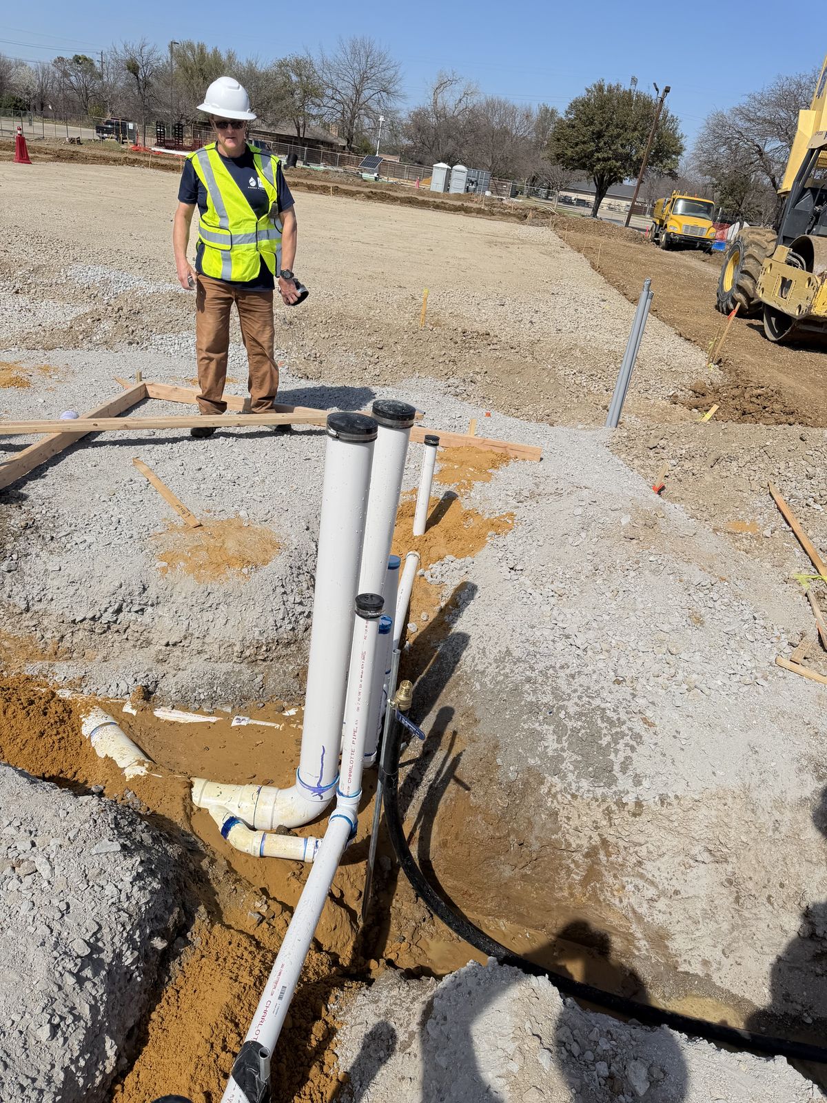 Hauser Plumbing technician inspecting a commercial foundation drain-waste-vent rough-in on a DFW jobsite